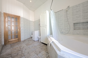 A bathroom with a bathtub, toilet, and shower.