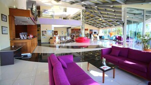 A spacious lobby with a high ceiling, a reception desk, a purple sofa, and a coffee table. - Dalaman Airport Lykia Thermal & Spa Hotel (Dalaman)