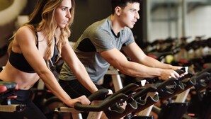 Two people exercising on stationary bikes in a gym with rows of equipment. - Dalaman Airport Lykia Thermal & Spa Hotel (Dalaman)