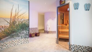 A spa area with a large painting of a beach scene, a wooden bench, and a tiled floor.