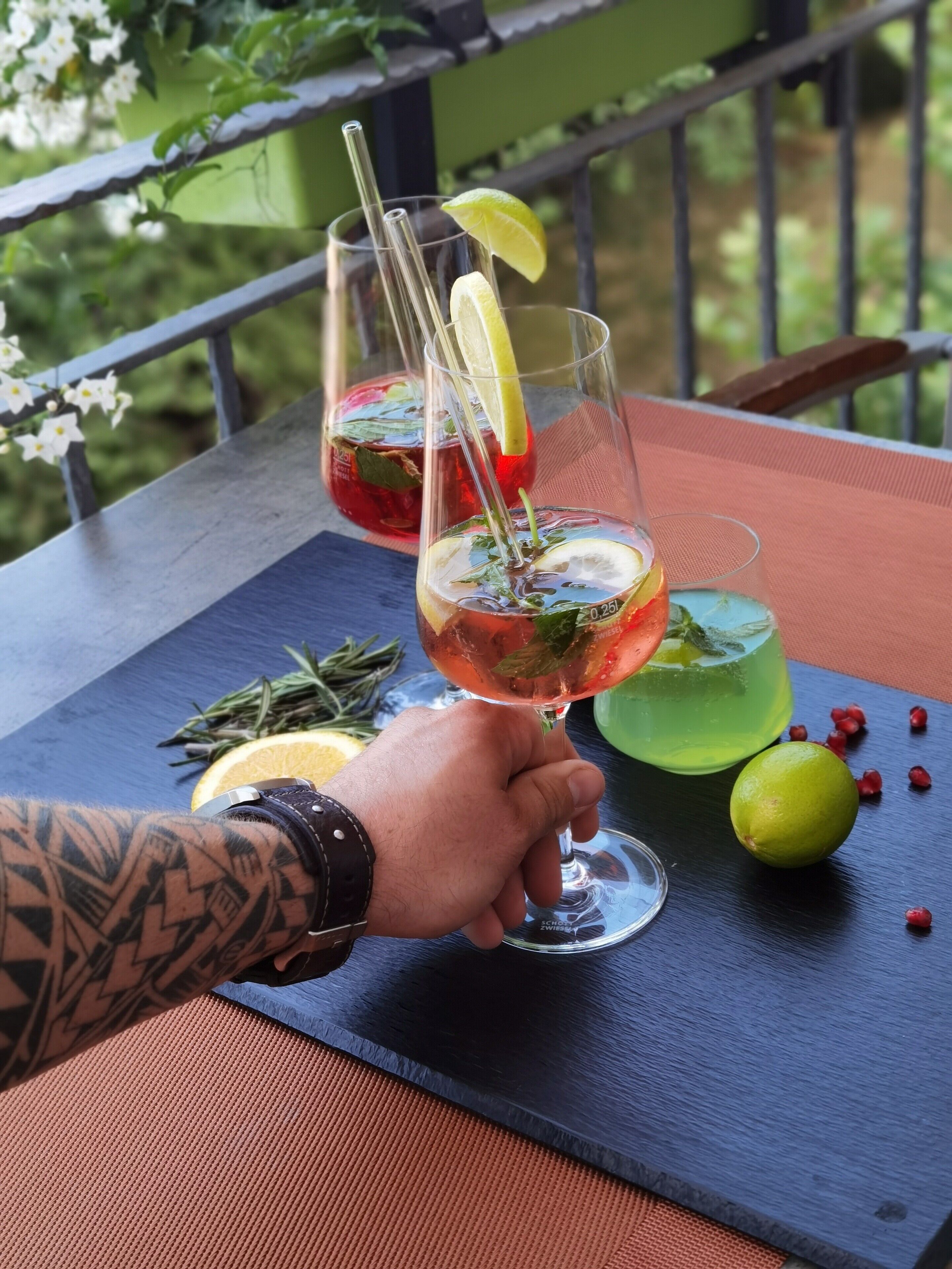 Twee cocktails op een tafel, met een hek op de achtergrond.