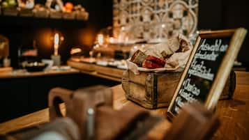 A wooden counter with a rustic appearance, a chalkboard menu, and a decorative wall in the background.