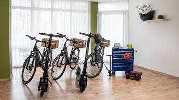 Een kamer met fietsen, een blauwe opbergunit en een houten vloer.
