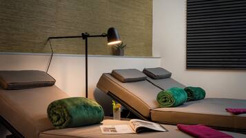 Relax in a comfortable room with a reclining chair, table, and floor lamp.