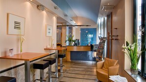 Un área de recepción moderna con mostrador, asientos y vista al escritorio de recepción.