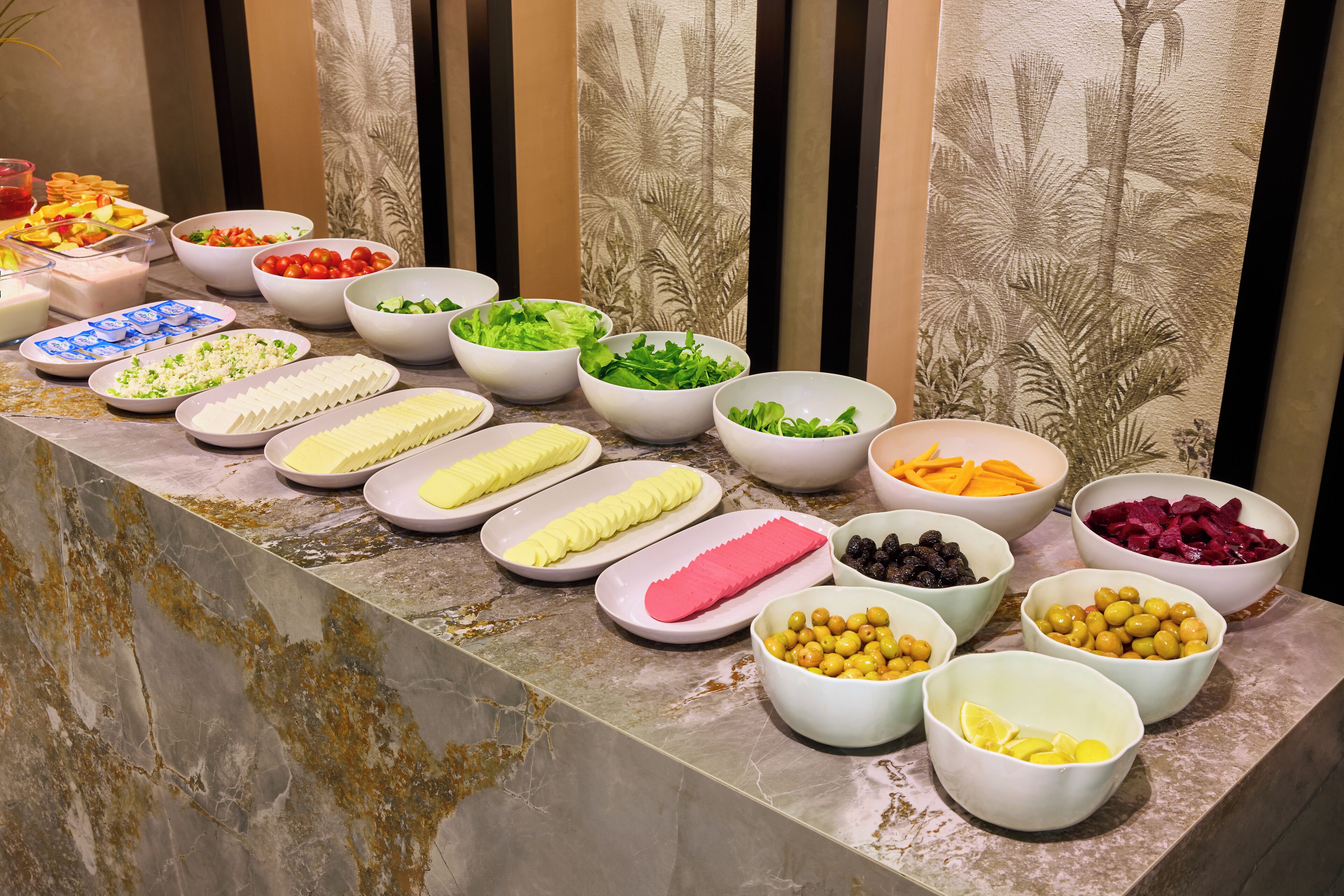 Un buffet proposant une variété de plats et d’accompagnements, disposés sur un comptoir en marbre.