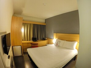 A hotel room with a large bed, a desk with a computer, a chair, and a television. - ibis Montenegro (Montenegro)