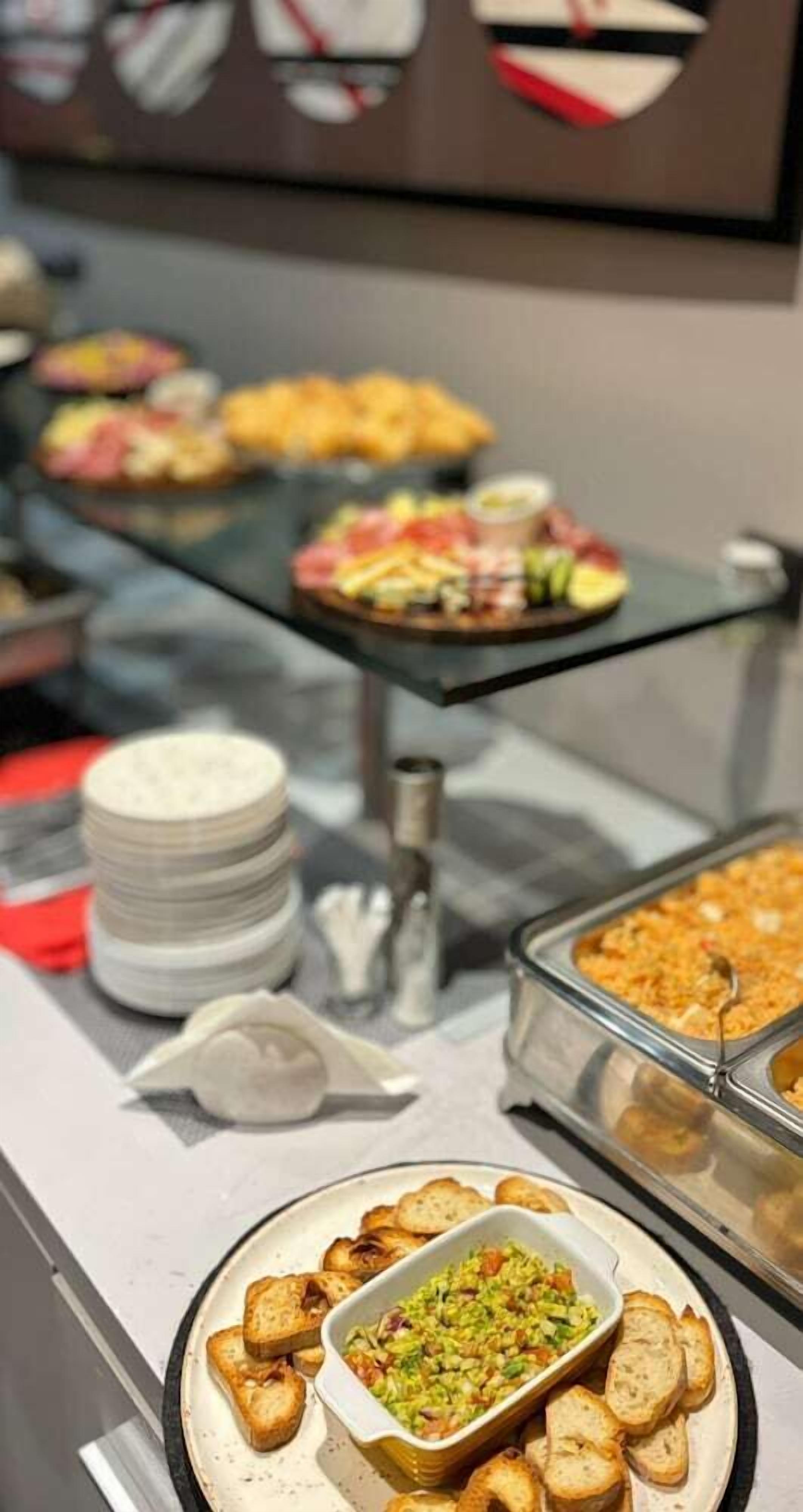 En buffet med forskellige retter, herunder en skål med grøntsager og et brød.