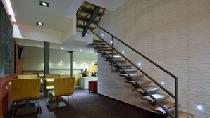 A modern interior with a unique staircase design, a dining area, and a kitchen. - Artloft Hotel (Nis)