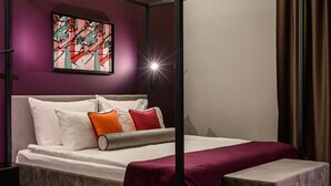 A modern bedroom with a bed, pillows, and a bedside table. - Artloft Hotel (Nis)