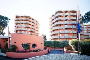 A modern multi-story hotel with circular balconies and a distinctive pink facade.