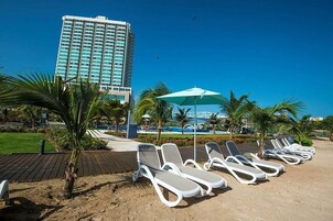 Privat strand, vit sandstrand, solstolar och parasoller