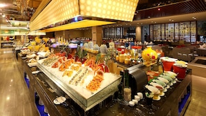 A buffet with various seafood and dishes, a bar area with seating, and a modern interior design. - Wyndham Grand Plaza Royale Changsheng Jiangyin (Wuxi)