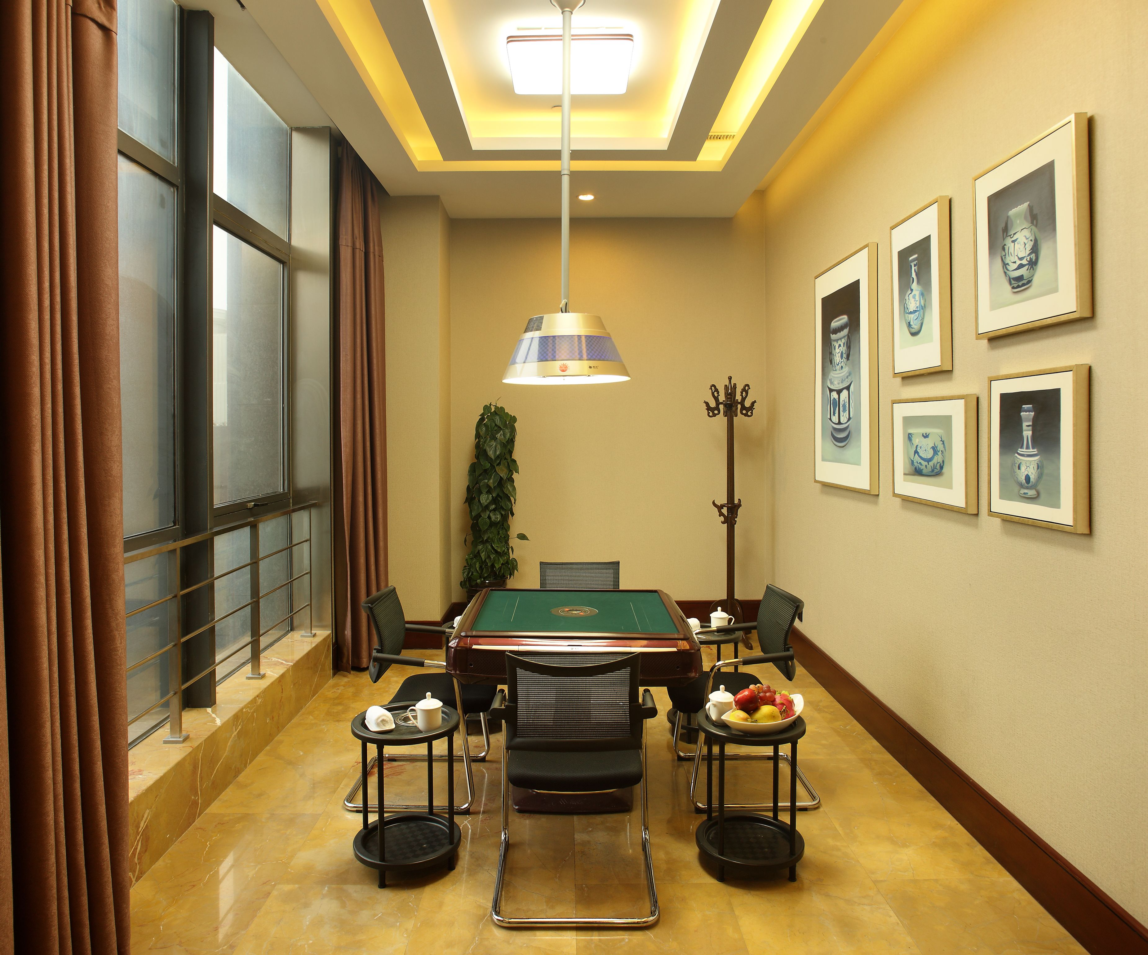 A conference room with a pool table, chairs, a coffee table, and framed artwork on the walls.