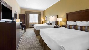 Quarto de hotel com duas camas, uma escrivaninha, televisão e um minibar.