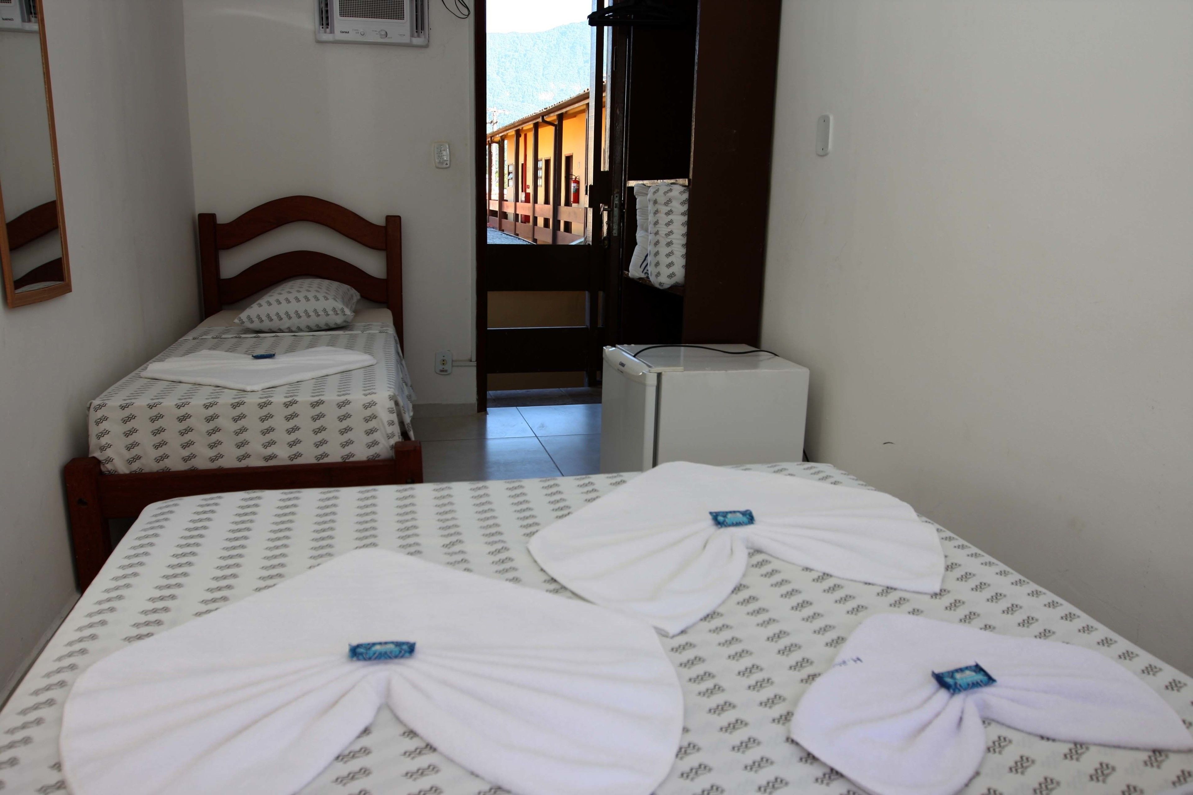 Une chambre à coucher avec un lit, une table de chevet, un miroir et une vue sur un balcon.