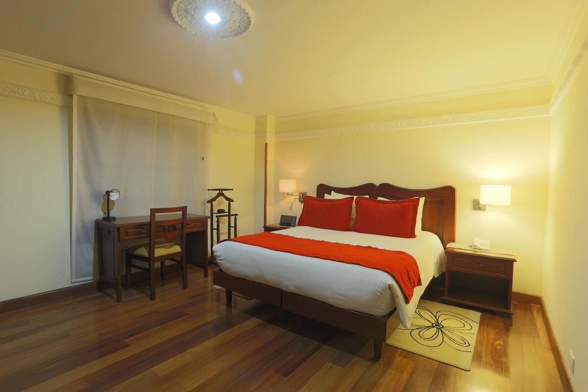 Ein Hotelzimmer mit einem hölzernen Bett, einem Schreibtisch und einem Stuhl.