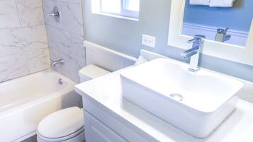 A bathroom with a bathtub, toilet, and sink.