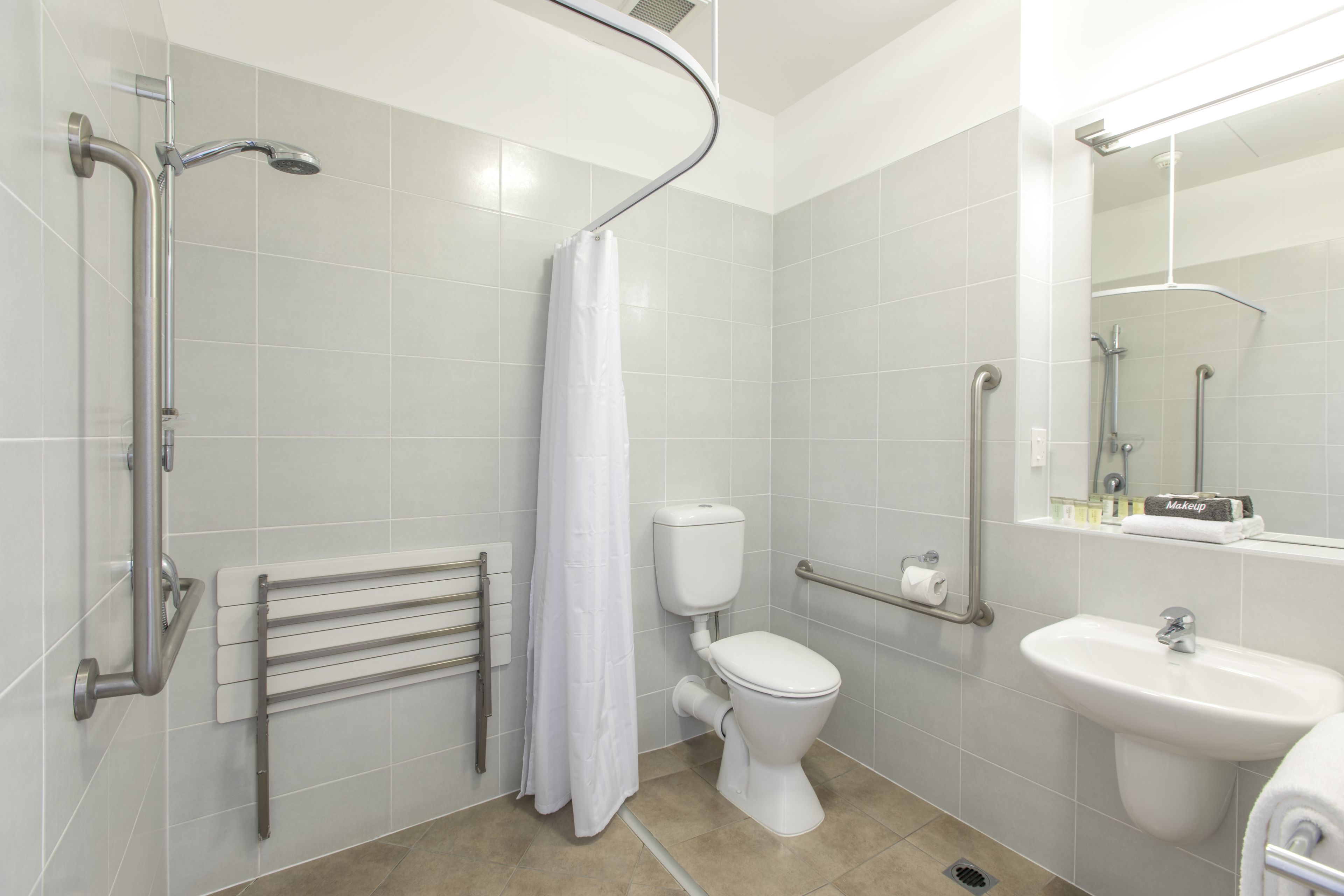 A modern bathroom with a shower, toilet, and sink.