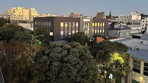 A modern building with a sign reading "QUEST" and a parking lot in front.