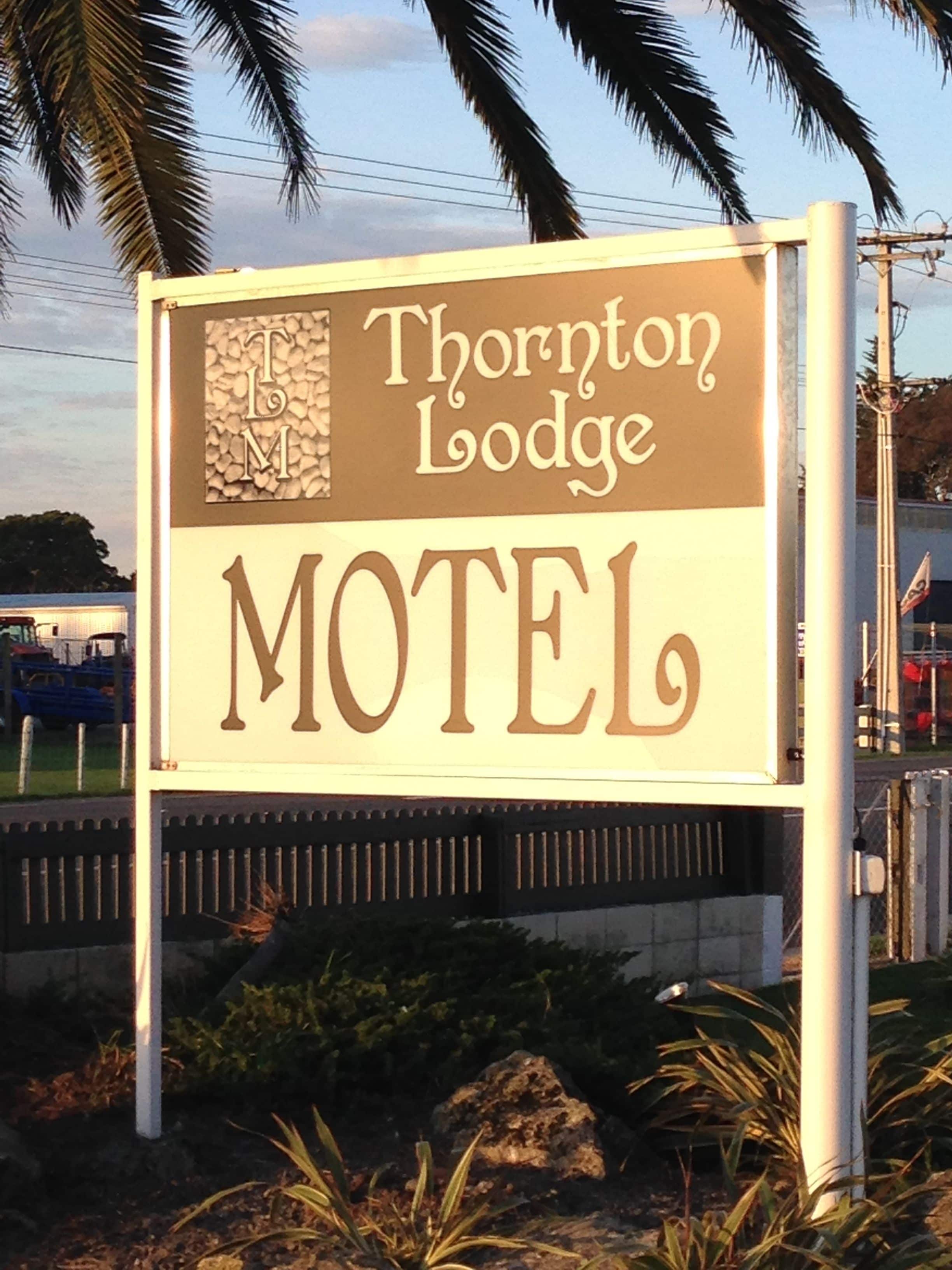 A motel sign with the name 'Thornton Lodge' and the word 'MOTEL' prominently displayed.