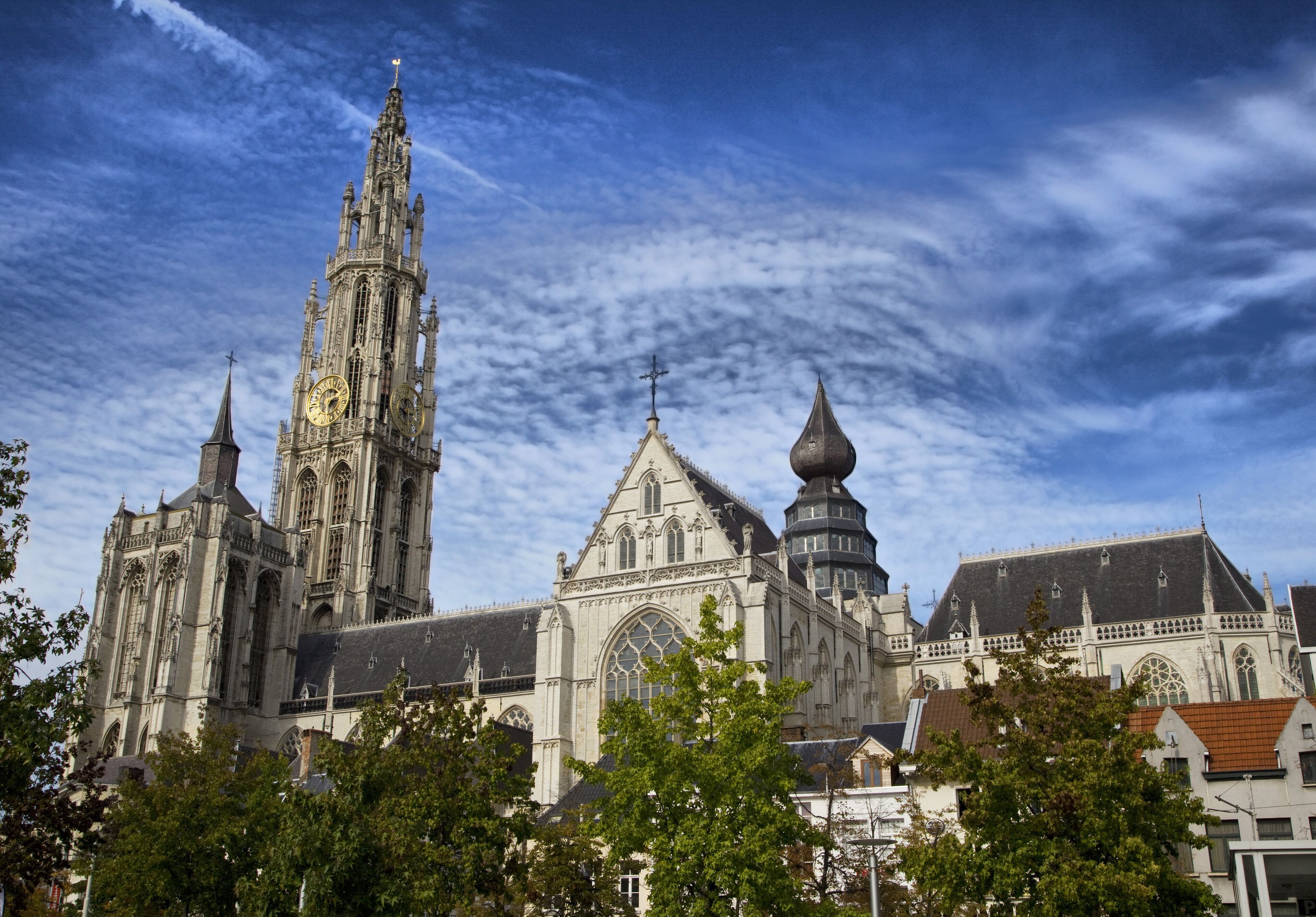 Una catedral histórica con arquitectura intrincada, que incluye una aguja alta y varias torres.