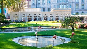A building with a large lawn, a pond with flamingos, and a fountain. - Holiday Inn Express Antwerp City Centre by IHG (Antwerp)