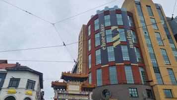 A building with a chocolate-themed facade, a traditional Chinese gate, and a sign for 'Panos.'