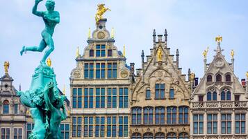 Een historisch gebouw met versierde architectuur, waaronder een opvallend standbeeld en decoratieve details.