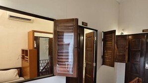 A hotel corridor with wooden doors, a white reception desk, and a red carpeted floor.