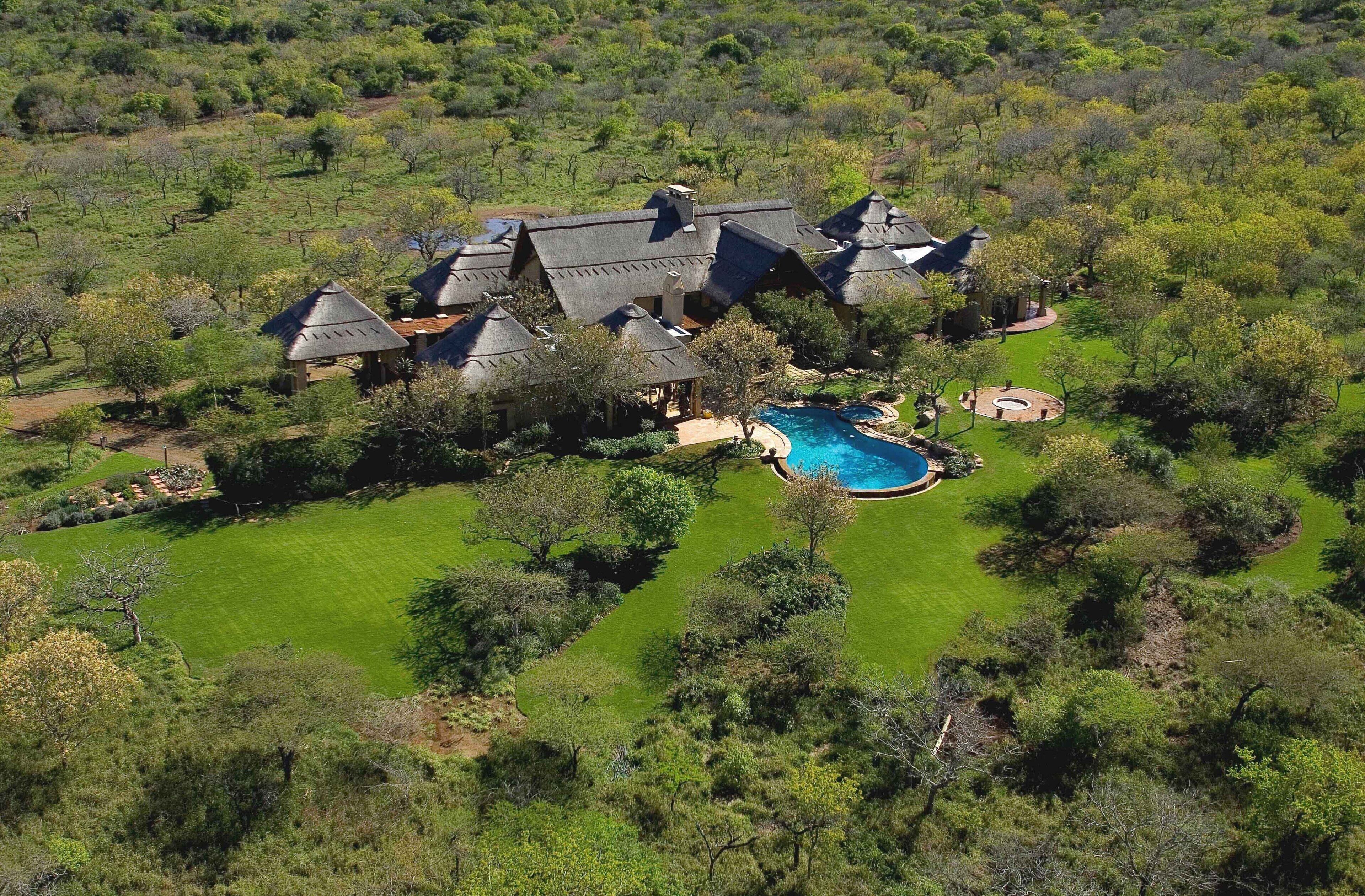 A large estate with multiple buildings, a swimming pool, and a well-maintained lawn.