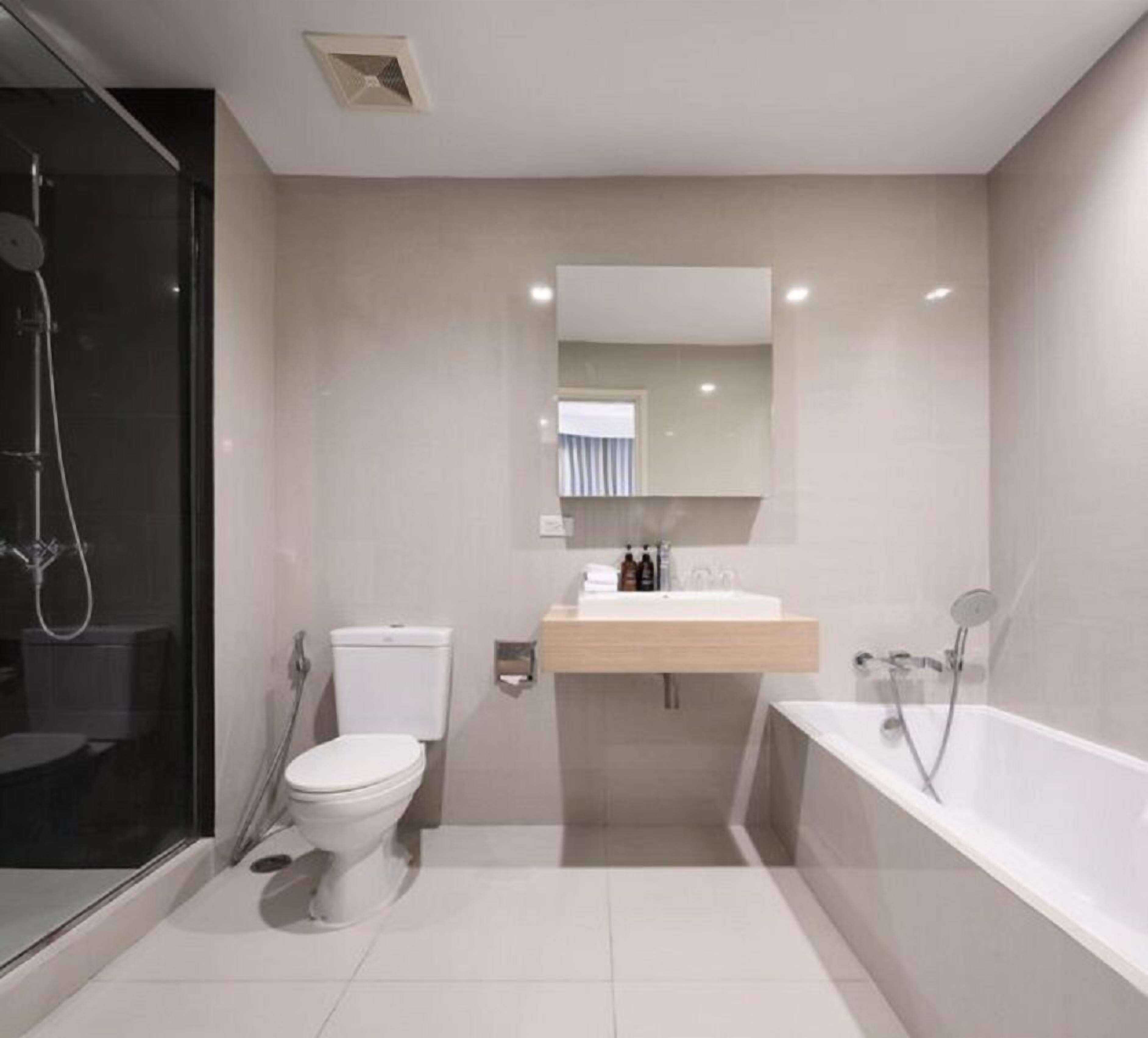 A modern bathroom with a toilet, sink, and bathtub.