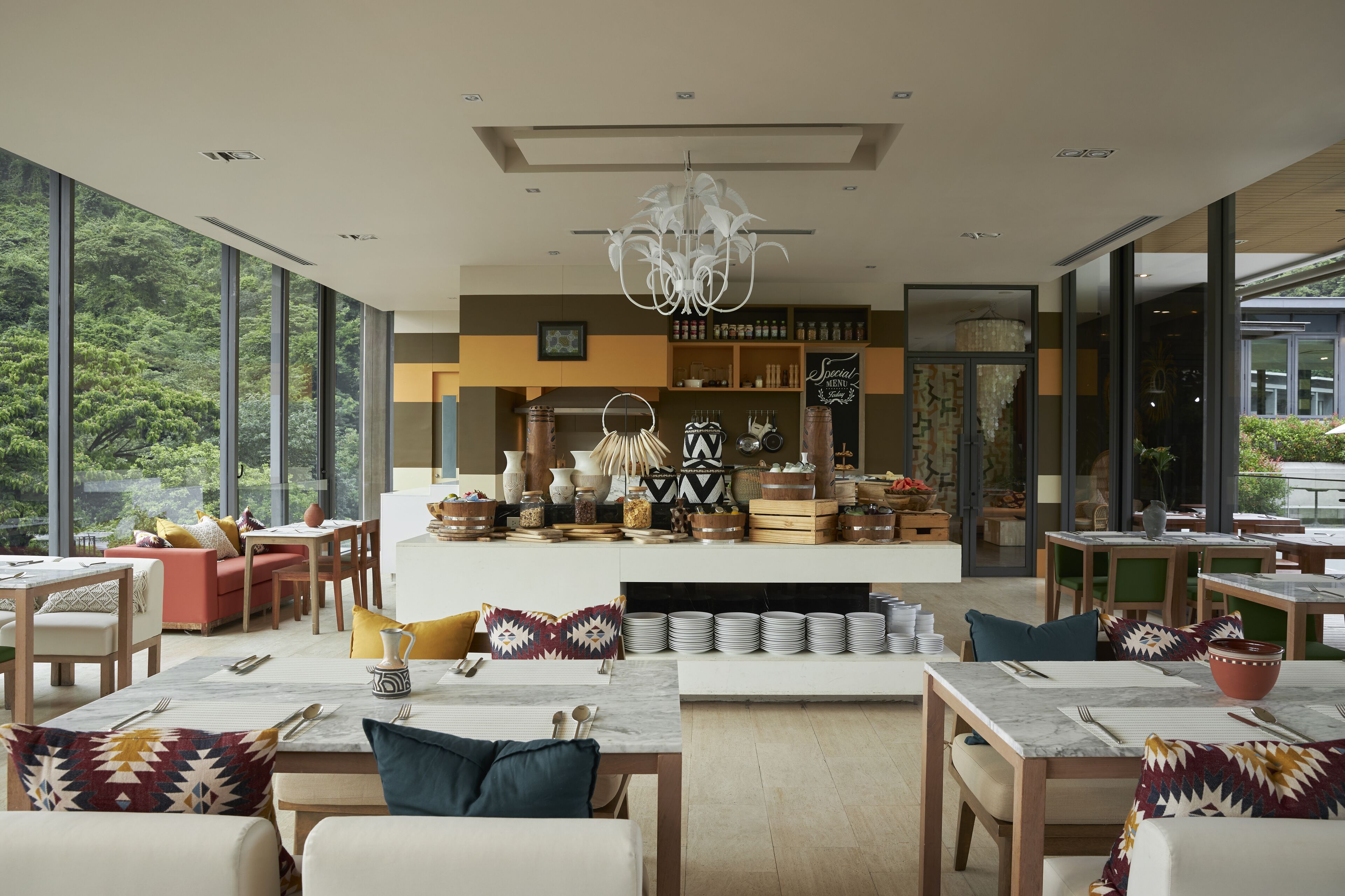 Un comedor espacioso con techos altos, ventanas grandes y una isla central con utensilios de cocina.