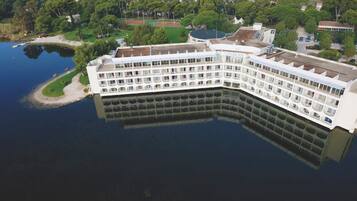 Un grand hôtel à plusieurs étages, doté de balcons et situé au bord d’une étendue d’eau.