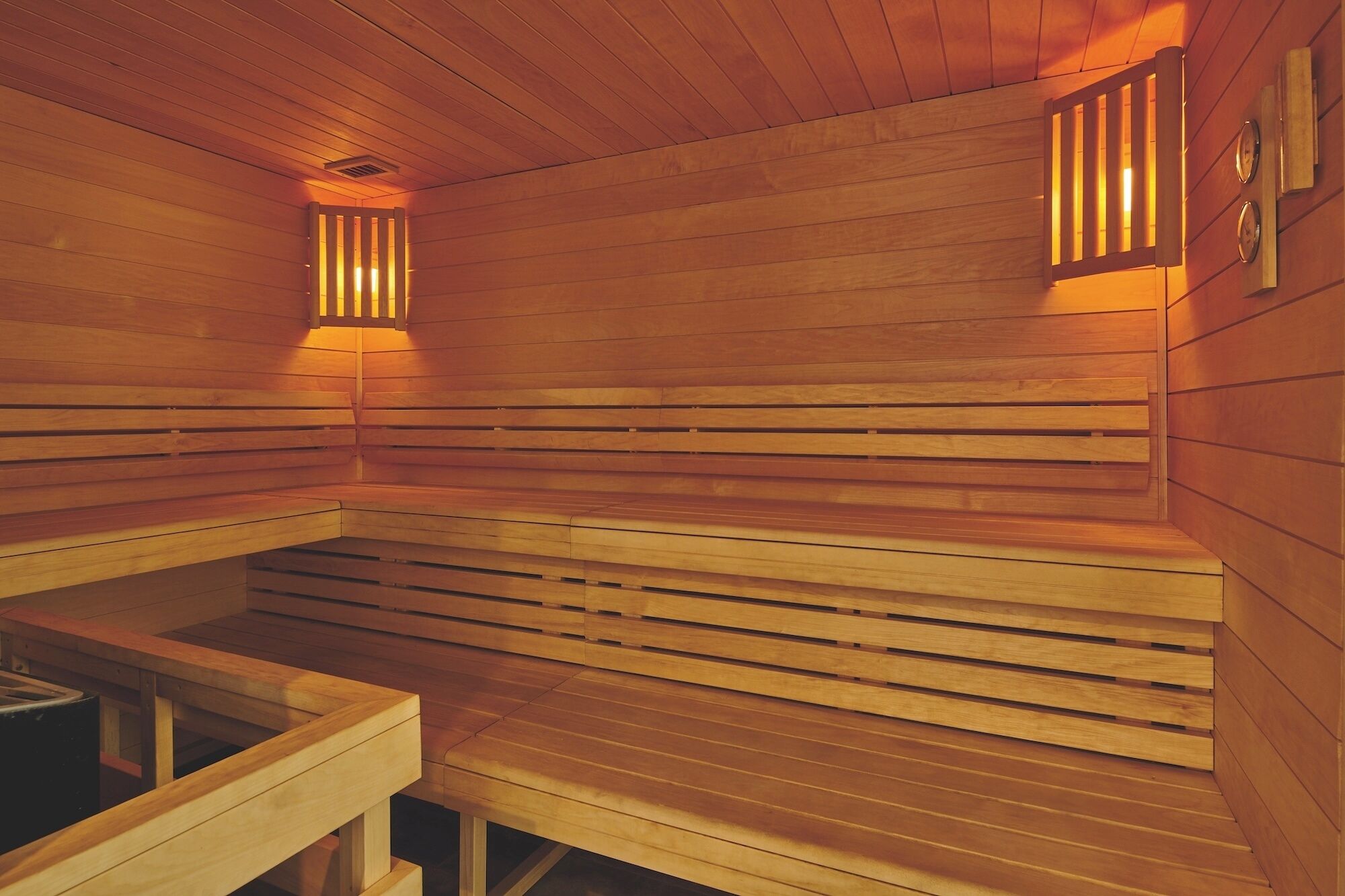 Una sauna con bancos de madera y paredes de listones.