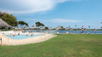 Relax by the serene pool surrounded by lush greenery and gazebos.