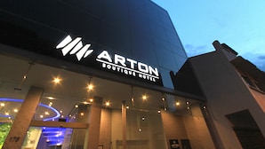 Exterior del Hotel Boutique Arton, con un letrero llamativo y entrada iluminada.