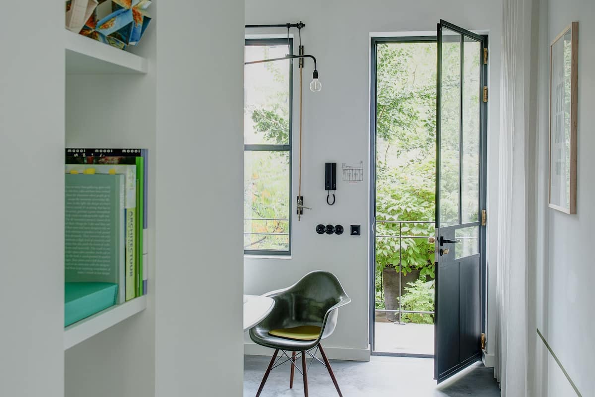 A modern interior with a chair, a desk, and a bookshelf.