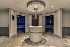 A modern bathroom with a central circular sink, tiled walls, and a ceiling light fixture. - Zenitude Hotel la Valadière, an Ascend Collection Hotel (Juvignac)