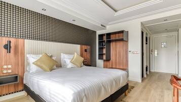 Un dormitorio moderno con una cama grande, estanterías empotradas de madera y un papel tapiz estampado.