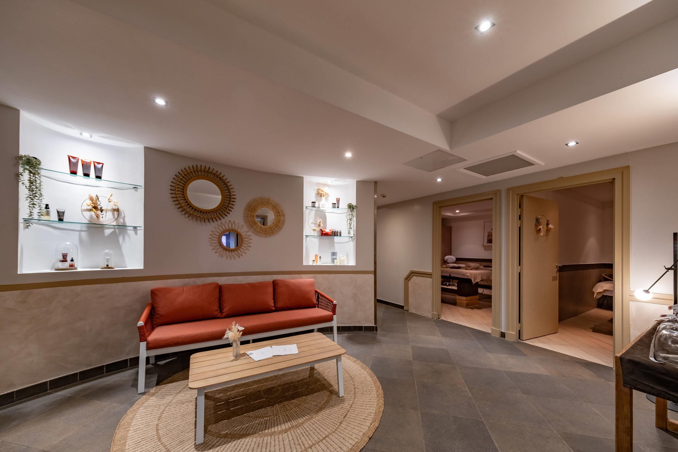 Una sala de estar moderna con un sofá rojo, una mesa de centro de madera y un espejo decorativo en la pared.