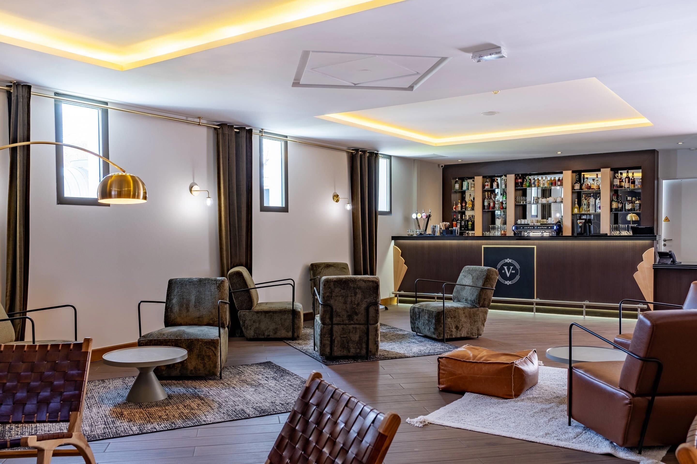 Um hall de hotel moderno com poltronas de couro, área de bar e uma grande janela.