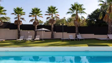 Una piscina cubierta, una piscina al aire libre de temporada, sombrillas