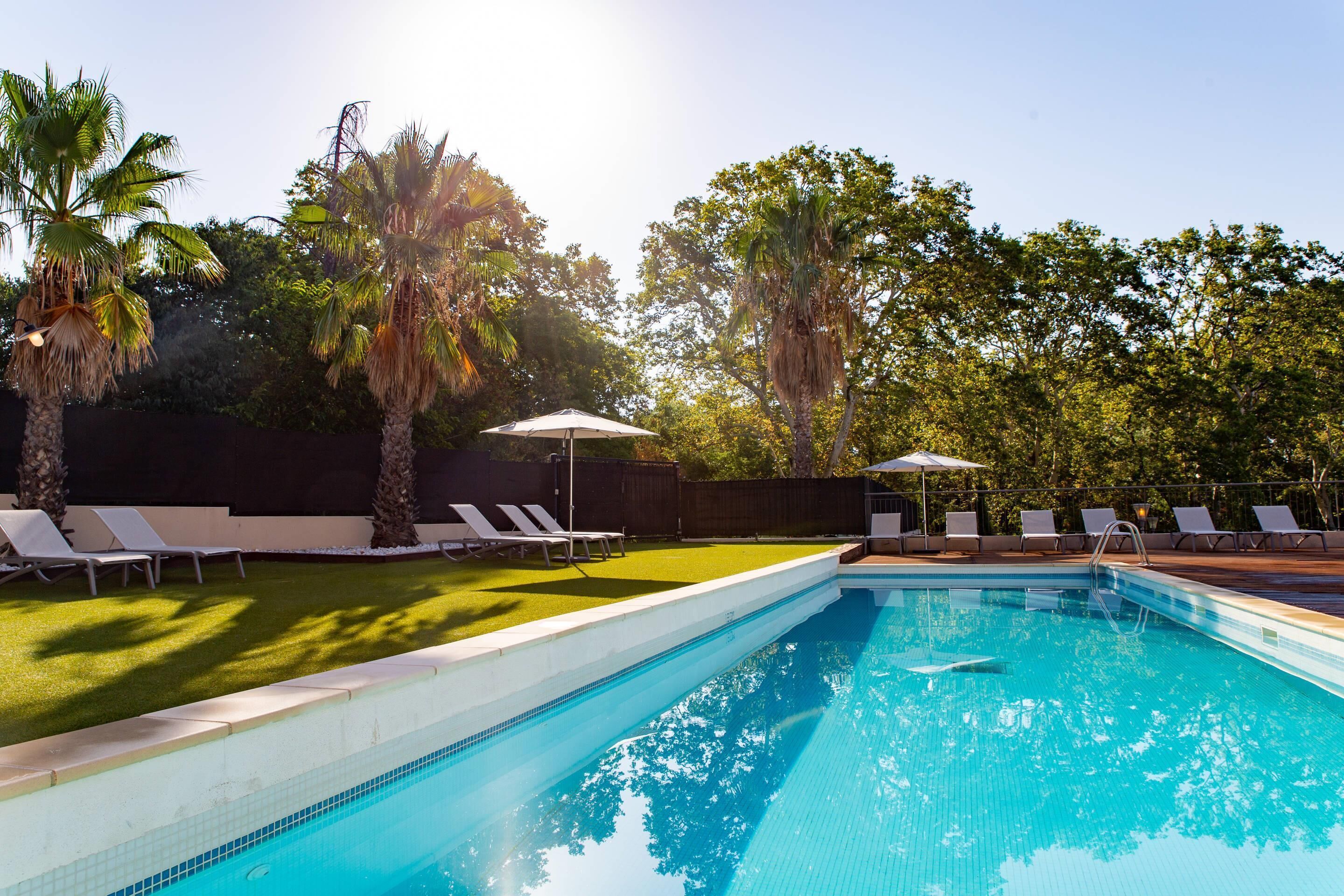 Una piscina cubierta, una piscina al aire libre de temporada, sombrillas
