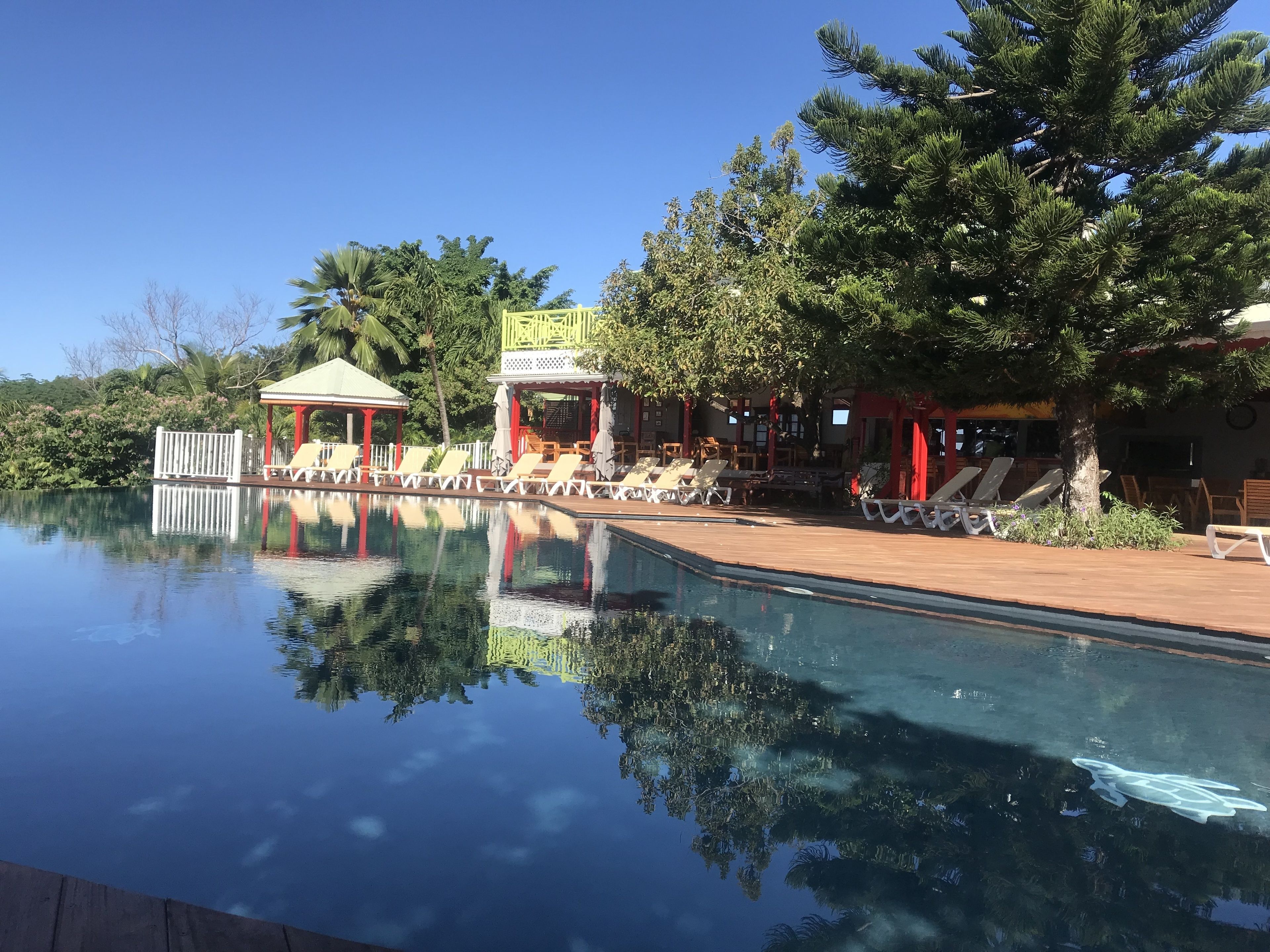 Une piscine aux eaux cristallines, dotée de chaises longues et d’un belvédère.