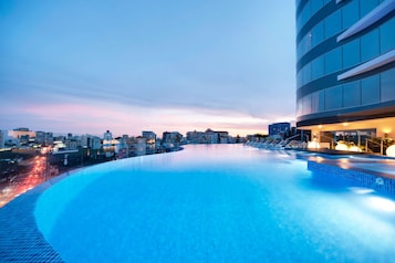 Una piscina al aire libre, sillones reclinables de piscina