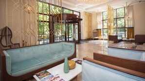 Eine geräumige Lobby mit einem hellblauen Sofa, einem Holztisch und einer großen Kronleuchter.