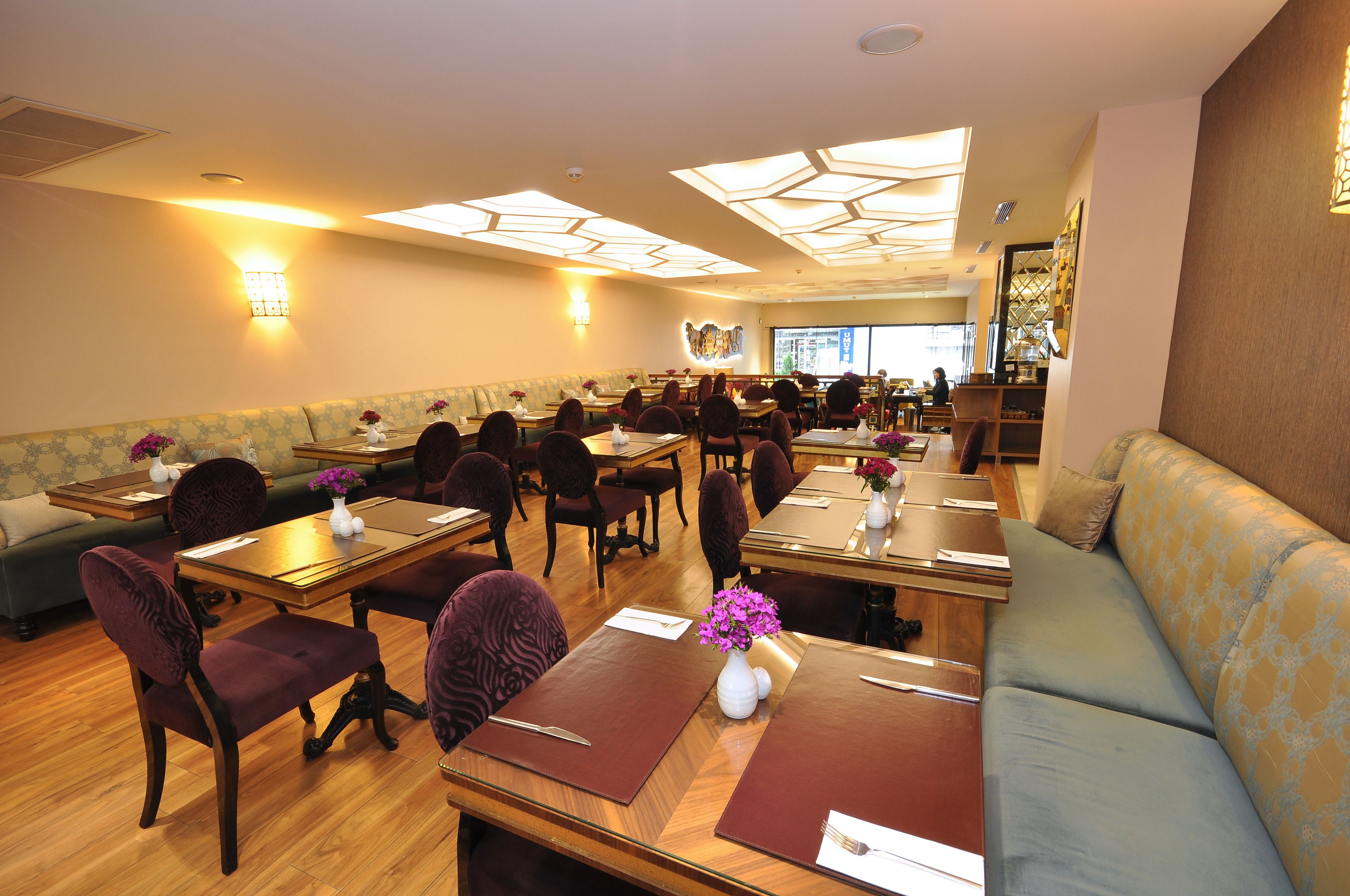 A restaurant with booths, tables, and a sofa.