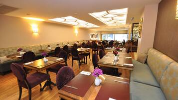 A restaurant with booths, tables, and a sofa.