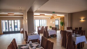 A spacious dining area with multiple tables and chairs, large windows, and a modern interior design. - Auberge du Moulin à Vent, The Originals Relais (Manou)